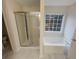 Bright bathroom featuring a separate shower and soaking tub beneath a window at 1156 Madison Green Sw Ln, Mableton, GA 30126