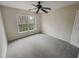 This bedroom features a ceiling fan, a window, and neutral-colored walls and carpets at 1156 Madison Green Sw Ln, Mableton, GA 30126