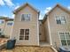 Rear view of townhome with tan vinyl siding and a small patio area, ready for outdoor enjoyment at 1485 Riverrock Trl, Riverdale, GA 30296