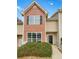 Welcoming townhouse with a mix of brick and vinyl siding, featuring large windows and well-maintained landscaping at 1485 Riverrock Trl, Riverdale, GA 30296