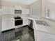 Efficient kitchen with stainless steel appliances, black tile flooring and ample counter space at 1485 Riverrock Trl, Riverdale, GA 30296