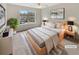 Comfortable staged main bedroom featuring a neutral color palette, large window, and stylish decor at 1485 Riverrock Trl, Riverdale, GA 30296
