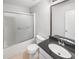 Bathroom featuring granite countertop, tiled flooring, and a shower-tub combination with glass doors at 4565 Bridle Point Pkwy, Snellville, GA 30039
