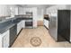 Well-lit kitchen featuring white cabinets, stainless steel appliances, dark countertops and a decorative tile floor design at 4565 Bridle Point Pkwy, Snellville, GA 30039
