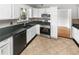 Bright kitchen featuring white cabinets, stainless steel appliances, dark countertops and a decorative tile backsplash at 4565 Bridle Point Pkwy, Snellville, GA 30039