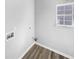 Clean laundry room featuring hardwood flooring and utility connections at 4565 Bridle Point Pkwy, Snellville, GA 30039