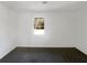 Minimalist bedroom featuring carpet, natural light from window, and plain white walls at 5407 Effingham Ct, Lithonia, GA 30038