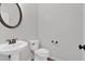 This powder room features a pedestal sink with bronze fixtures, a toilet, and neutral paint at 1235 King Springs Se Ct, Smyrna, GA 30080