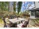 Inviting back patio with stone flooring, outdoor dining set, and tranquil views of the landscaped yard at 203 Northside Nw Dr, Kennesaw, GA 30144
