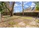 Overgrown back yard with a wooden fence, grass yard, and large trees, offering ample privacy at 203 Northside Nw Dr, Kennesaw, GA 30144