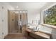 Spa bathroom features a soaking tub, a separate shower, and a window with wooded views at 203 Northside Nw Dr, Kennesaw, GA 30144