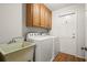 Functional laundry room with a utility sink, cabinetry, and modern appliances at 203 Northside Nw Dr, Kennesaw, GA 30144