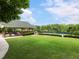 Expansive lawn with outdoor seating, a grill area, and tennis courts in the background, perfect for outdoor gatherings at 203 Northside Nw Dr, Kennesaw, GA 30144