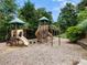 Community playground with slides, climbing structures, and a cushioned ground for safety and surrounded by mature trees at 203 Northside Nw Dr, Kennesaw, GA 30144