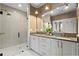 Modern bathroom featuring dual sinks, white cabinetry, and a glass-enclosed shower with gold fixtures at 3475 Landen Pine Ne Ct, Atlanta, GA 30305