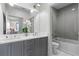 Well-lit bathroom with dual sinks, gray cabinets, and a shower/tub combo behind a glass door at 3475 Landen Pine Ne Ct, Atlanta, GA 30305