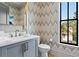Elegant powder room with chevron wallpaper, modern vanity, and natural light from the window at 3475 Landen Pine Ne Ct, Atlanta, GA 30305