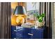 Bedroom with cobalt blue dresser, gold hardware, a gold lamp, and an orchid on a window sill at 3475 Landen Pine Ne Ct, Atlanta, GA 30305