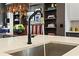Close-up of kitchen sink with matte black hardware, open shelving, and a view of dining area with leather banquet at 3475 Landen Pine Ne Ct, Atlanta, GA 30305