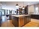 Open concept living room with island, modern chandelier, and stainless steel appliances at 3475 Landen Pine Ne Ct, Atlanta, GA 30305
