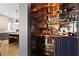 Elegant wet bar with copper accents, mirrored shelves stocked with glassware, and a built-in beverage refrigerator at 3475 Landen Pine Ne Ct, Atlanta, GA 30305