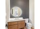 Modern powder room with a floating wood vanity, gold hardware, round mirror, and contemporary design at 372 Karen Dr, Alpharetta, GA 30009