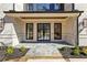 Spacious front porch featuring stone flooring, brick columns, and double-door entry at 372 Karen Dr, Alpharetta, GA 30009