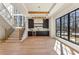Bright living room with large windows, wooden floors, bar area, and wooden staircase at 372 Karen Dr, Alpharetta, GA 30009