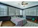 Bright bedroom with natural light from multiple windows, a ceiling fan, and wood-look laminate flooring at 3891 Kraddle Creek Dr, Covington, GA 30014