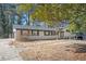 Ranch-style home featuring brick exterior, black shutters, and mature trees in a tranquil setting at 1887 King Charles Sw Rd, Atlanta, GA 30331