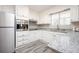Modern kitchen with stainless steel appliances, ample counter space, and gray wood-look floors at 1887 King Charles Sw Rd, Atlanta, GA 30331