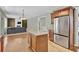 Open-concept kitchen with island, stainless steel refrigerator, and view into the living room at 1384 Stone Bay Sw Dr, Atlanta, GA 30331