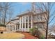 Back of house featuring expansive windows and a sunroom, surrounded by beautiful landscaping at 1884 Point River Dr, Duluth, GA 30097