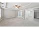 Large carpeted bedroom with tray ceiling, ceiling fan, and tiled entryway at 1884 Point River Dr, Duluth, GA 30097