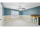 This bedroom features blue walls, carpet floors, a ceiling fan, and a window with natural light at 1884 Point River Dr, Duluth, GA 30097