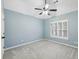 This bedroom includes blue walls, carpet floors, a ceiling fan, and a window with natural light at 1884 Point River Dr, Duluth, GA 30097