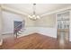 Chandelier-lit dining room boasts hardwood floors, wainscoting and views to the foyer at 1884 Point River Dr, Duluth, GA 30097