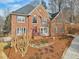 Aerial view of a stately brick home with a manicured lawn and front yard at 1884 Point River Dr, Duluth, GA 30097