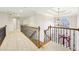 Bright hallway with wooden railing, neutral carpet, and view of the front door chandelier at 1884 Point River Dr, Duluth, GA 30097