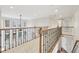 Upstairs hallway with wood and metal railing overlooking a large living space at 1884 Point River Dr, Duluth, GA 30097