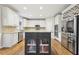 Well-lit kitchen featuring an island with granite countertops, stainless steel appliances, and hardwood floors at 1884 Point River Dr, Duluth, GA 30097