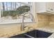 Close up of kitchen sink with granite countertops and a window with a view to the backyard at 1884 Point River Dr, Duluth, GA 30097