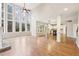 Open-concept living room with hardwood floors, fireplace, large windows, and seamless flow to the kitchen at 1884 Point River Dr, Duluth, GA 30097