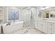 Luxurious bathroom with freestanding tub, patterned window, and glass shower at 1884 Point River Dr, Duluth, GA 30097