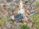 Aerial view of a home featuring a sunroom, stone patio, and circular driveway at 1884 Point River Dr, Duluth, GA 30097