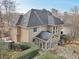 A view of the rear exterior with a sunroom, stone patio, and manicured landscaping at 1884 Point River Dr, Duluth, GA 30097