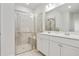 Bright bathroom featuring a glass-enclosed shower with a bench and a double vanity with white cabinets at 3891 Shelleydale Dr, Powder Springs, GA 30127