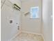Bright laundry room featuring practical shelving, tile flooring, and a window for natural light at 3891 Shelleydale Dr, Powder Springs, GA 30127
