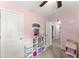 Bright bedroom with pink walls, storage shelves, and decor creating a vibrant and organized space at 3940 Village Estates Ct, Cumming, GA 30040