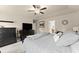 Spacious main bedroom featuring a ceiling fan, wall-mounted television, and a view into the ensuite bathroom at 3940 Village Estates Ct, Cumming, GA 30040